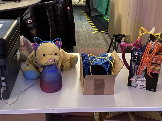 Yellow soft toy cat wearing blue cat ears