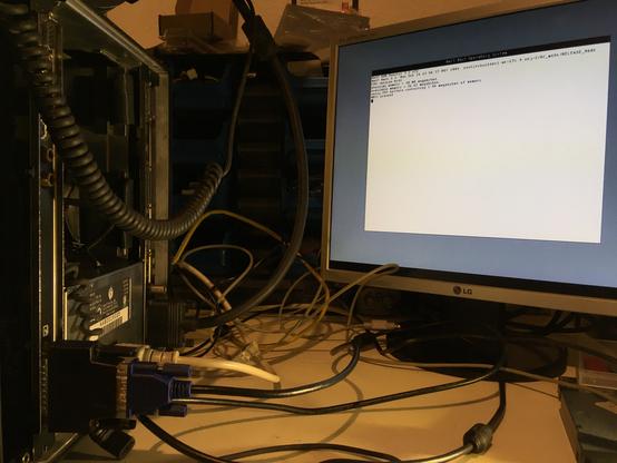 photo showing the back side of a NeXTcube, there’s a LCD screen connected to the 13W3 connector of a NeXTdimension card, showing output from the ROM Monitor
