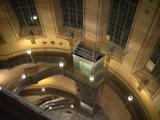 Von der Kuppel des Eingangs zum alten Elbtunnel wurde in das Innere herab fotografiert. Zu sehen sind das gewölbte Mauerwerk mit den langen Fenstern und sich im ZickZack herabschlängelnde Treppen.