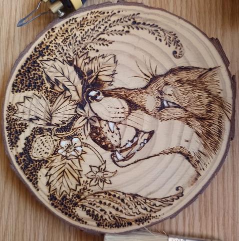 Phyrography on wood, a  fox eating strawberries