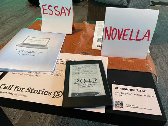 Foto des eReaders bei Saal Y, daneben ein Schild mit Infos zur Novella