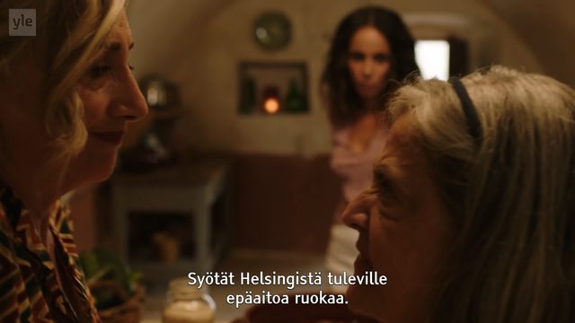 Kuvakaappaus Yle Areenasta, mainitusta ohjelmasta, jossa kaksi vähän vanhempaa naista seisoo vastakkain, taustalla taas seisoo nuorempi nainen. 

Ohjelmatekstityksessä lukee: Syötät Helsingistä tuleville epäaitoa ruokaa.