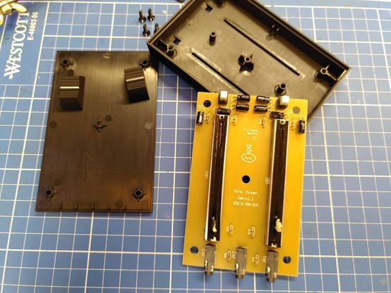 Disassembled device: screws are hidden below rubber feet, slider knobs are held in place with a piece of masking tape (friction fit)