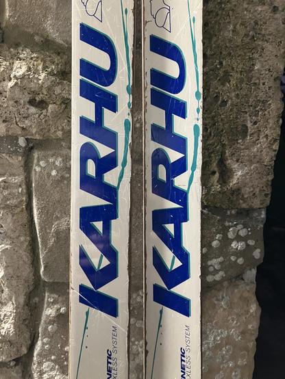 Kahru logo on a pair of waxless Nordic skis leaning against a stone wall