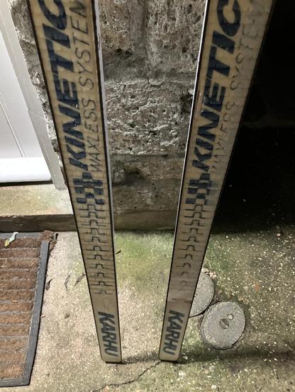 Waxless base of a pair of Kahru Nordic skis leaning against a stone wall