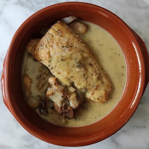 Bacalao con setas en salsa de calabacín emplatado en tartera de barro.