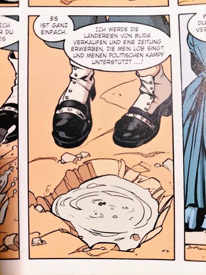 Comic-Panel: Es sind Kinderfüße vor einer Pfütze zu sehen. In einer Sprechblase steht: "Es ist ganz einfach. Ich werde die Ländereien von Blida verkaufen und eine Zeitung erwerben, die mein Lob singt und meinen politischen Kampf unterstützt...!"