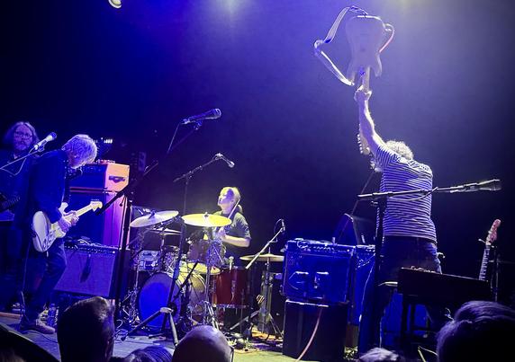 Yo La Tengo performing at the Bowery Ballroom min NYC on Friday December 27, 2024. Pat Sansone from Wilco Is sitting in on electric guitar. Ira Kaplan is holding his electric guitar over his head as if he's going to smash it against the ground.
