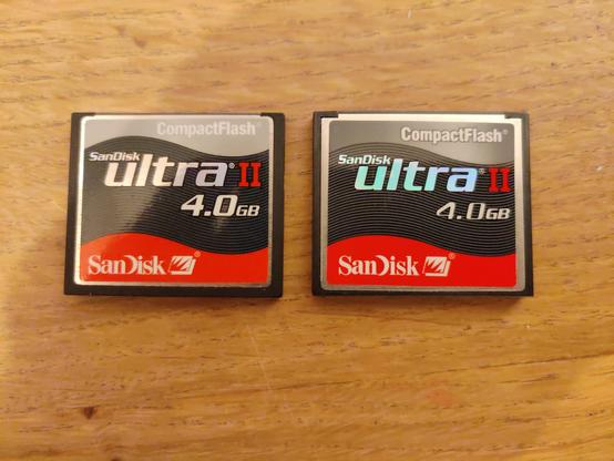 The front faces of two 4.0GB Sandisk Ultra II compact flash cards. They look almost identical.