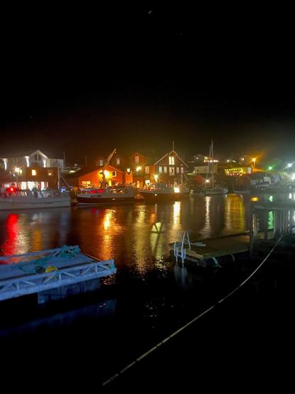 Color image of a decorated wharf in a small fishing village off the coast of Trondelag, Norway. Image shows the boat houses and homes along the wharf colorfully decorated for Christmas.