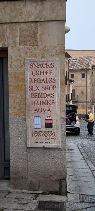Una foto de un anuncio en la pared donde se apuntan las cosas que se venden en ese recinto de dispensadores automáticos (eso que en España llamamos vending y hemos recortado como concepto al mundo entero). Uno de los tienes es: sex shop.