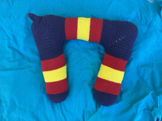 Crocheted neck pillow in Salvation Army colours.