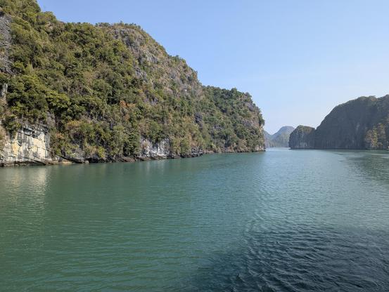 A serene bay, framed by towering limestone cliffs.