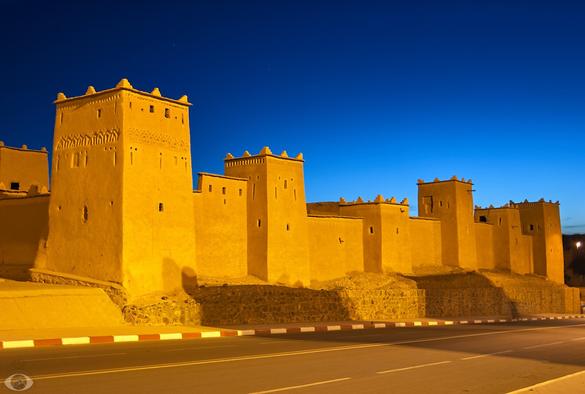 Angular fort made of clay-loam gloaming yellow in a deep-blue sky.