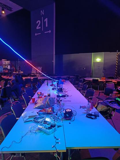 A table with a bit of mess.

There is an LED strip going from the far end of the table to the upper left of the picture. There is a string of LED pixels on the table, and the far half of it is lit in blue