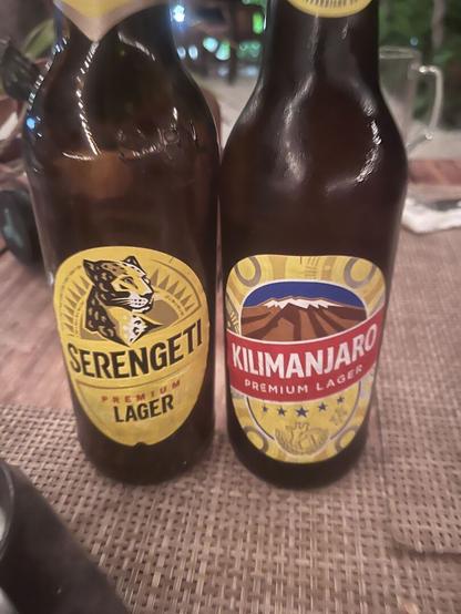Two bottles of beer, one called Serengeti (left) and one Kilimanjaro (right)