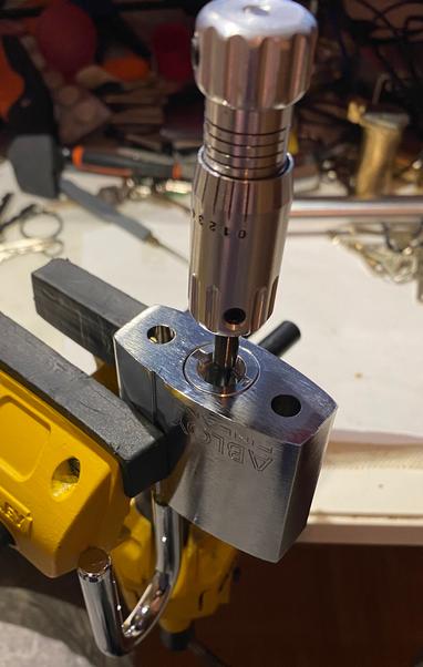 Photo of one of the chunkier Abloy Classic padlocks with its shackle open and a 2-in-1 pick sticking out of it