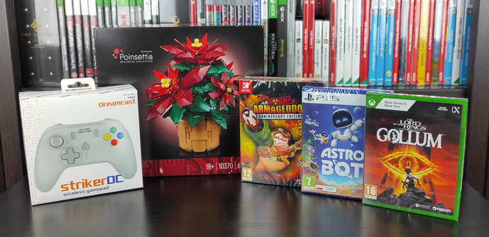Zdjęcie z comiesięcznymi zdobyczami. Od lewej -  kontroler "strikerDC wireless gamepad" firmy Retro Fighters, zestaw LEGO Botanical Collection "Poinsettia", pudełko z grą "Worms Armageddon: Anniversary Edition" w edycji Kolekcjonerskiej na konsolę Nintendo Switch, pudełko z grą "ASTRO BOT" na konsolę PlayStation 5 oraz pudełko z grą "The Lord of the Rings: Gollum" na konsolę XBOX Series X oraz XBOX One.