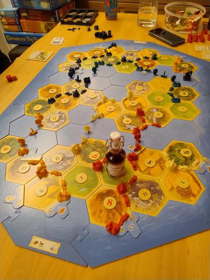 Ein Foto von einer Partie Siedler. Blau führt und der Räuber wird von einer Flasche Sanddorn Likör verkörpert.