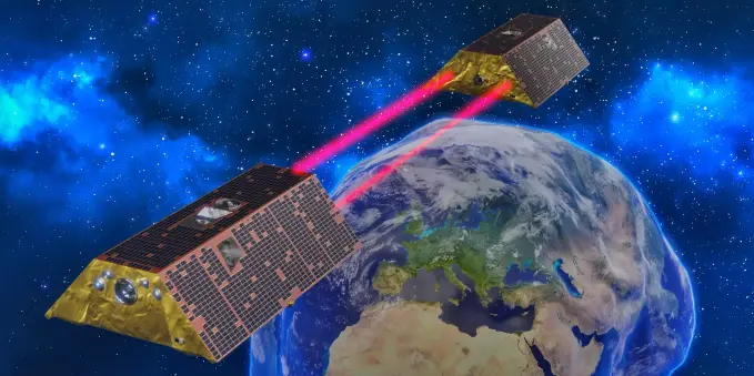 Computergeneriertes Bild von zwei Satelliten, die mit zwei roten Laserstrahlen verbunden sind, über der Erde Die Form der Erde ist stark übertrieben verformt, um das örtlich unterschiedliche Schwerefeld darzustellen, das die Satelliten messen.