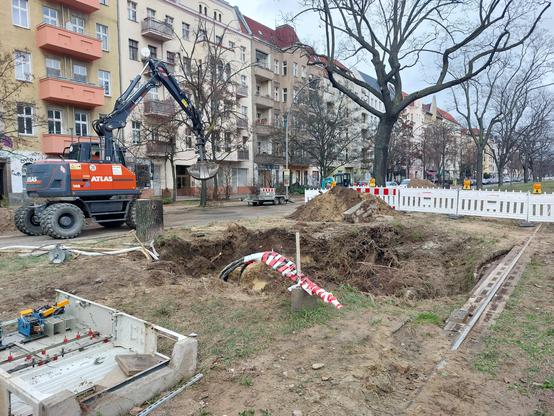 Loch neben Tramgleis im Grünstreifen, Absperrungen, gekappte Kabel, im Hintergrund ist ein Bagger zu sehen