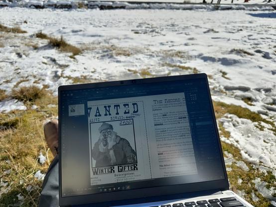 Photo of the game jam submission being worked on a laptop, outdoors while sitting in the snow