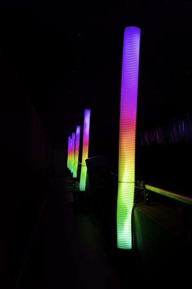 A row of colorfully illuminated vertical tubes.