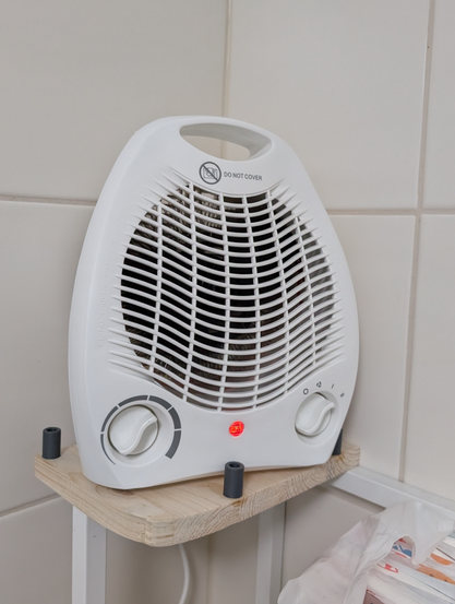 Electric forced air space heater on a wooden board