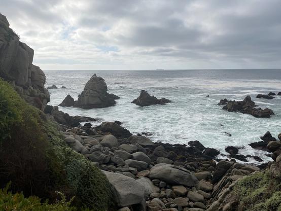 Spiky dark grey rocks piercing the ocean surface