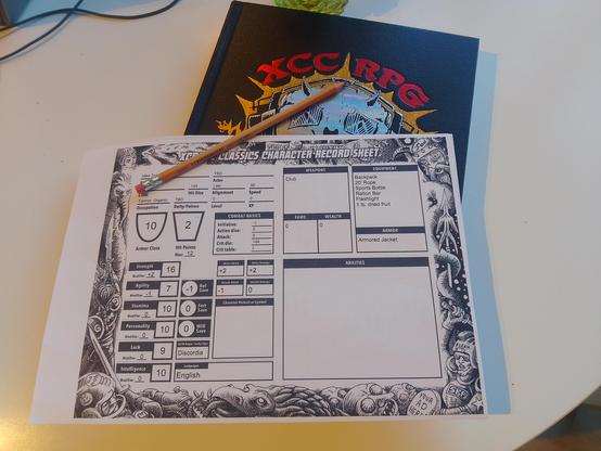 a character sheet for XCrawl Classics on top of the limited edition book (faux leatherbound with metallic embossed logo).