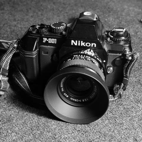 Black and white photo of the Nikon F-301 camera with a Soligor 28 mm f/2.8 lens attached.