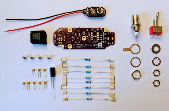 electronic components sorted and ready to assemble ozel's low-cost spectrometer for measuring radioactivity, smol purple pcb, a few thru hole resistors, capacitors, an opamp, panel-mount toggle switch and bnc jack