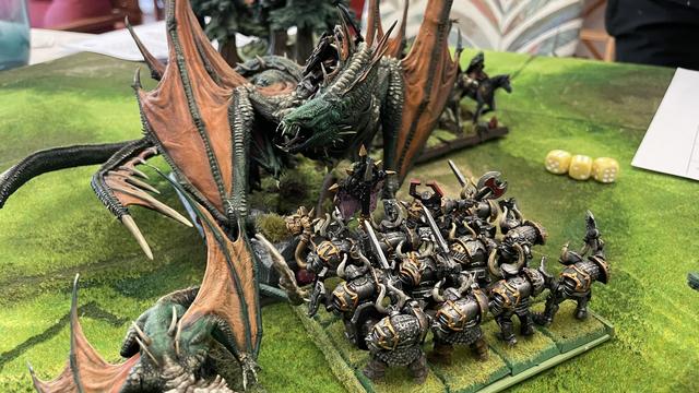 The elf dragon lord decides to eat some abyssal foot soldiers for breakfast. A very large 3D printed dragon stands in combat against a 6th edition block of Chaos Warriors)