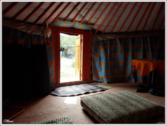 Bildbeschreibung:
Eine Jurte von innen mit geöffneter Tür.