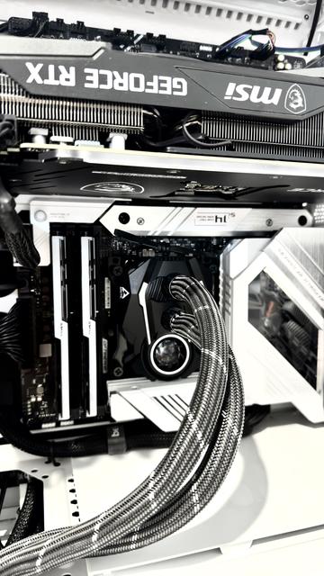 The internals of my primary workstation/rig. I designed it for 3D rendering, so it is stacked with a bunch of expensive (was at the time) hardware. Note that it is in inverted configuration to make it as quiet as possible (the radiator hoses don't reach around the monstrous graphics card the other way). The aesthetic is primarily white and black, with some aluminium/silver. There are braid-wrapped grey hoses with white stripes, curling their way to the CPU, which looks like a little black coffin with a tiny fan at the bottom in a bubble. Overall quite neat, even for a starting point. The case is white and the motherboard is black with white details. One or two other colours make their way in at the fringes with colour coded wires, but that's it. It is high contrast and very stark. That's why it got the nickname tk421 initially.