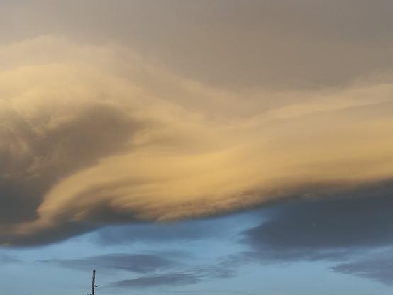 Nubes con tonos naranjas y azules al amanecer. Las nubes parecen muy densas y tienen formas suaves como un bote de hummus