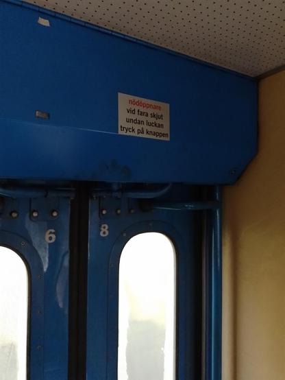 Cartel dentro del tren en otro idioma. El texto del cartel es:

Nodoppnare
Vid fara skjut
Undan luckan
Tryck pa knapppen