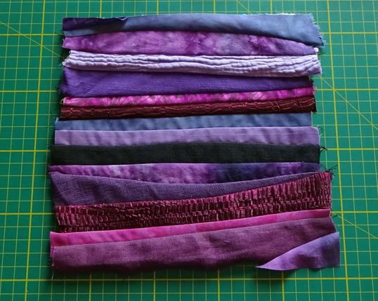The “purples” square from the previous photo, this time in natural light. The differences in texture are more obvious here, with the double gauze puffing up a little, the linens showing a slightly slubby texture, and the shiny polyester doing its best impression of burgundy snakeskin.