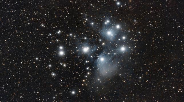 M45 Pleiades. Bright star cluster with blue nebulosity around the main stars.