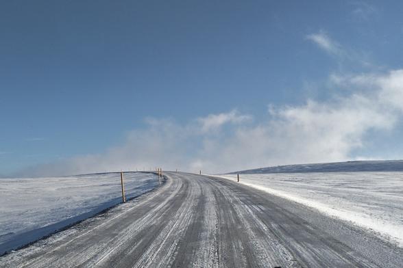 A start snowy road with a blue sky and clouds on background