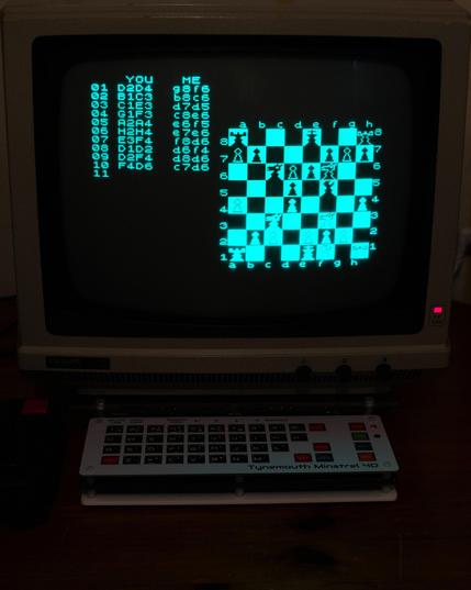 Photo of a chess game running on the Jupiter Ace clone computer. It is being displayed on a green screen CRT monitor. The screen composes of a board layout on the right-hand side, with chess notation history on the left. I wanted to perform a castling manoeuvre but I have no idea how this program accepts such a command.