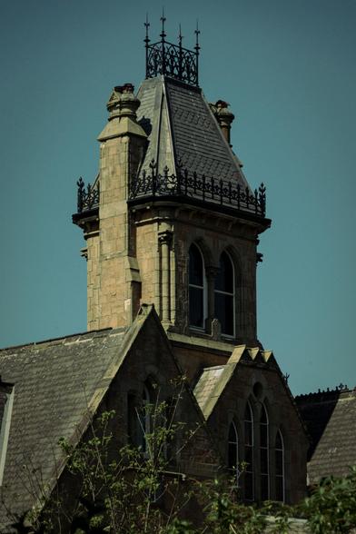 Turret and gables on a Victorian house in the gothic revival style with sun and shadows.