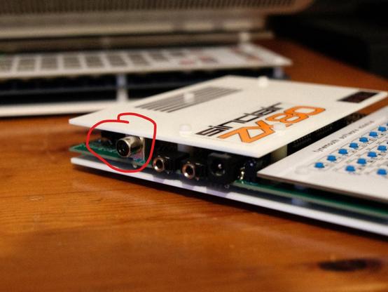 Photo showing angled side view of the computer. Highlighted is the newly filed down video output socket.