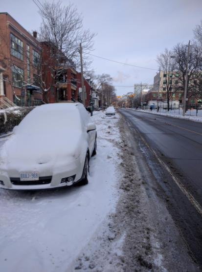 Parked cars with bicycle lane, completely covered in snow