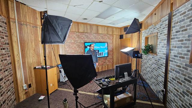 Our studio. Some lights. Connor standing in front of a television.