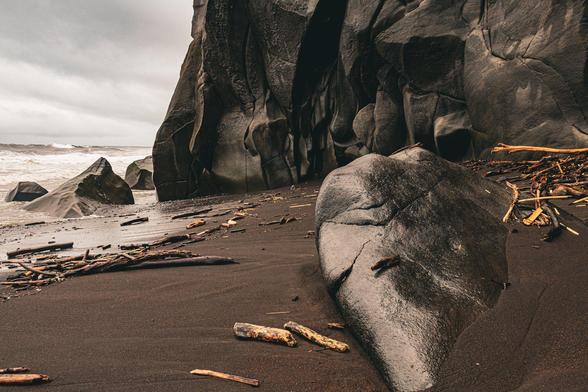 An ominous volcanic outcrop looms over the black sands of Ti Sable beach in Réunion 🌋