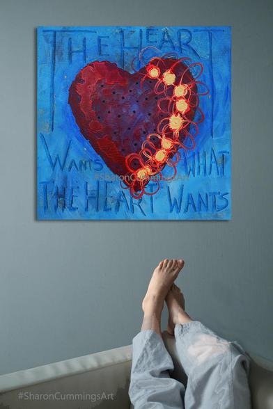 Colorful red heart with gold flowers on blue. It says The Heart Wants What The Heart Wants by artist Sharon Cummings.