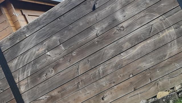 Zweimal schleifspuren am bretterzaun, wie mit Zirkel gezogen rund, weil die Äste vom Oleanderbusch im Wind sich in abgezirkelter Länge des Astes bewegen.