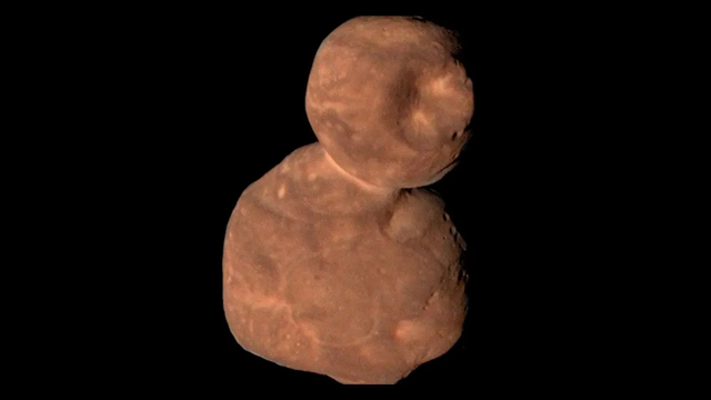 NASA New Horizons image of 486958 Arrokoth. Two lumpy, potato-shaped objects are stuck together. The near-true-color view is illuminated from the left.
