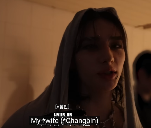 Dimly lit shot of Hyunjin in a hoodie. Caption: My *wife (*Changbin)